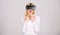 Woman wearing virtual reality goggles in grey background. Amazed young woman touching the air during the VR experience