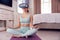 Woman Wearing Virtual Reality Headset Sitting On Yoga Mat In Bedroom At Home And Meditating