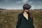 Woman wearing VR at the field next to the wind turbines