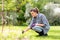 Woman weeding flowerbed at summer garden