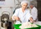 Woman weighing dough and preparing portioned pieces