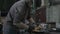 Woman welder or blacksmith employee wearing protection equipment grinding smooths steel and iron in an industrial workshop -