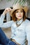 Woman in western wear in cowboy hat, jeans and cowboy boots.