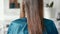 Woman with wet straight light brown hair sitting in hairdressing haircare salon