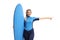 Woman in a wetsuit holding a surfboard and pointing to one side