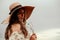 Woman wheat field nature. Happy young woman in sun hat in summer wheat field at sunset. Copy space, sunset, flare light