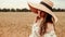 Woman wheat field nature. Happy young woman in sun hat in summer wheat field at sunset. Copy space, sunset, flare light