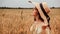 Woman wheat field nature. Happy young woman in sun hat in summer wheat field at sunset. Copy space, sunset, flare light