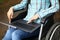 Woman in wheelchair in park with laptop on lap closeup