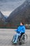 A woman in a wheelchair on a point view admires the high mountains. Thrust to life.