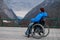 A woman in a wheelchair on a point view admires the high mountains. Thrust to life.