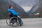 A woman in a wheelchair on a point view admires the high mountains. Thrust to life.