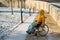 Woman in wheelchair relaxing in winter park.