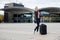 Woman With Wheeled Luggage Standing Outside Railroad Station