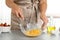 Woman whipping eggs at grey table, closeup. Cooking of delicious cake