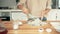 A woman whipping eggs whites with a whisk in a glass bowl