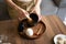 Woman whisking matcha green tea drink at home using tea ceremony set