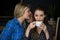 Woman whispering secret into female friend ear in cafe