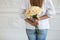 Woman in white blouse hides bouquet behind her back. Selective focus