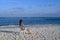 A woman on a white chair on the beach at the water edge on an island in the Indian Ocean admires the sunset sky