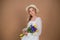 .A woman in a white dress and hat holds a bouquet of tulips and irises. March 8. Women\'s Day. Women\'s holiday. Mom\'s holiday. Bouq