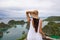 Woman in white dress and hat looking tropical seascape