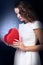Woman in white dress holding magic heart box