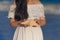 Woman in a white dress holds a starfish, hands closeup