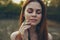 woman in white dress with a praying mantis in hand close-up