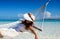 Woman in white dress relaxing on a hammock