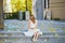 Woman in white dress sitting on the stairs on famous Montmartre hill in Paris, France at early morning