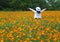 Woman in white feeling happy in the blooming yellow Cosmos flowers field