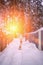 A woman in a white jacket and a dog walk in the snow after a winter storm in a snowy forest in the setting sun. Active dog walking