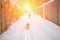 A woman in a white jacket and a dog walk in the snow after a winter storm in a snowy forest in the setting sun. Active dog walking