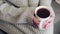 Woman in a white knitted sweater holds a mug of delicious hot tea