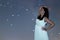 Woman in white long dress under starry night. Woman looking to starry night. Woman under night sky,