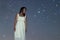 Woman in white long dress under starry night Woman under night sky,