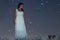Woman in white long dress under starry night Woman under night sky,
