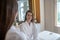 Woman in white robe discussing spa procedures with cosmetologist