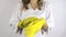 Woman in white robe smock put on yellow rubber gloves on hands