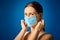 Woman in white shirt shows how to wear a mask during a pandemic