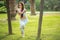 Woman in white sports outfit performing Yoga Eagle pose outdoor, in park meadow.