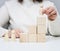 Woman in a white sweater puts a wooden figurine on the podium. The concept of employee search, career advancement. Talented