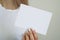 Woman in white t-shirt hold white blank paper sheet in hand