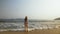 Woman in a white tunic on the beach, near the stormy sea. Blonde