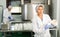 Woman in white uniform working in shaping workshop of cheese dairy