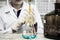 The woman who\'s the scientist is doing the experiment, the titration of the reagent in the flask