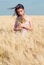 Woman with Wild Flowers in the Wheat Field in Summer.