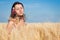 Woman with Wild Flowers in the Wheat Field in Summer.