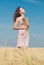 Woman with Wild Flowers in the Wheat Field in Summer.